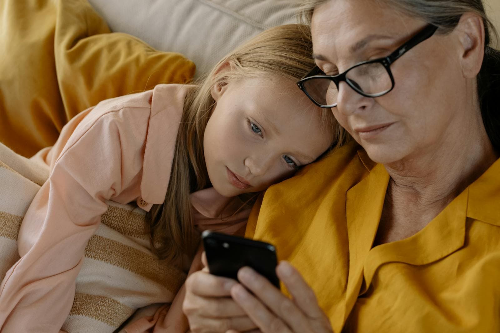 Abuela y nieta mirando juntas la pantalla del celular